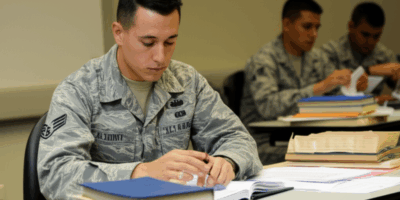 Military officer candidate studying test materials at desk